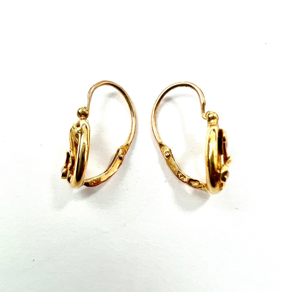 A pair of 9ct yellow gold Art Nouveau dormeuse earrings featuring an oval frame enclosing a botanical scroll motif with a seed pearl accent. View III