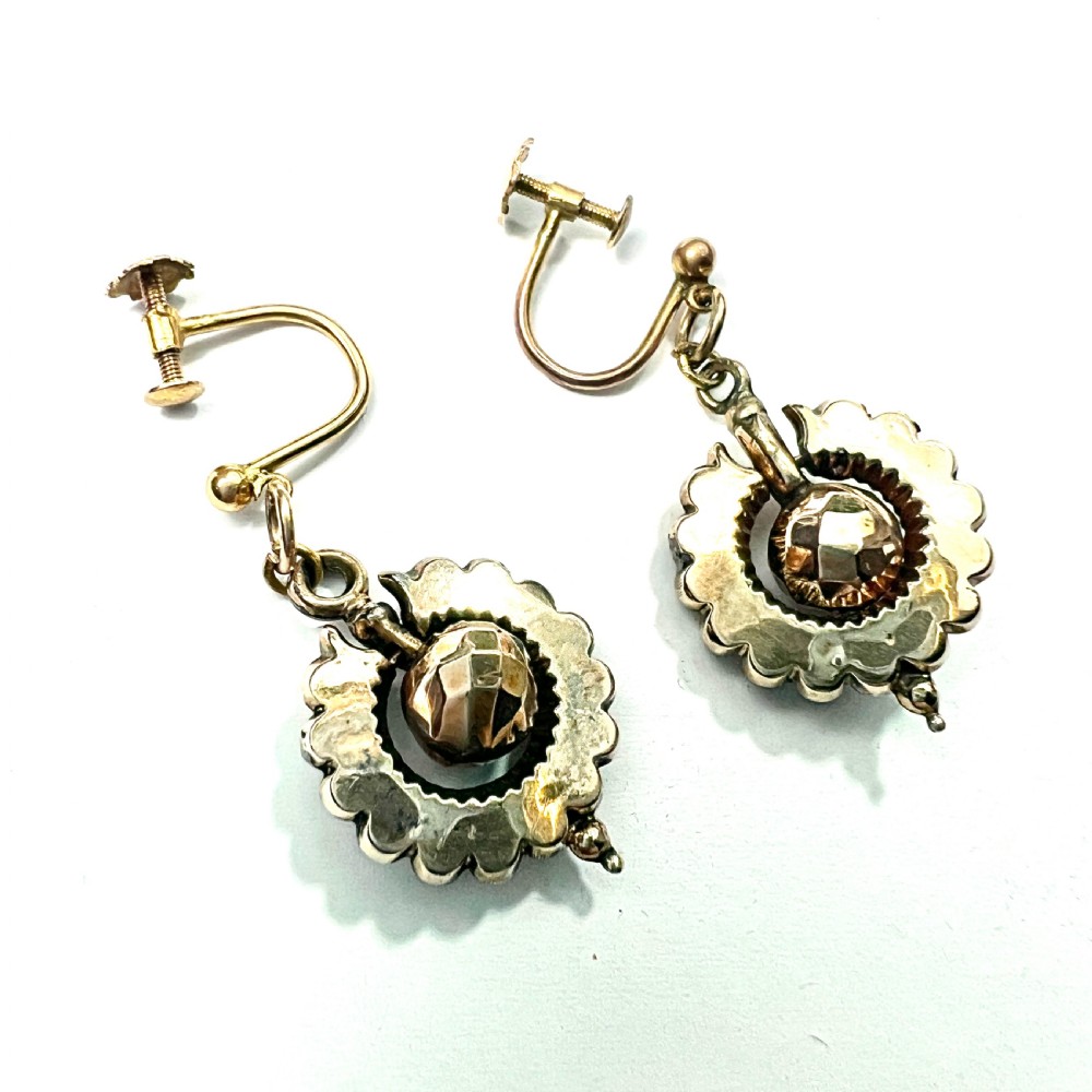 A pair of Victorian 9ct gold drop earrings featuring scalloped borders and central spherical motifs, displayed in a navy blue velvet jewellery box. View V