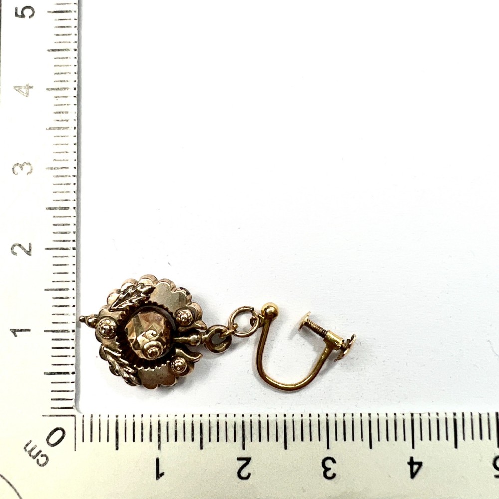 A pair of Victorian 9ct gold drop earrings featuring scalloped borders and central spherical motifs, displayed in a navy blue velvet jewellery box. View VIII