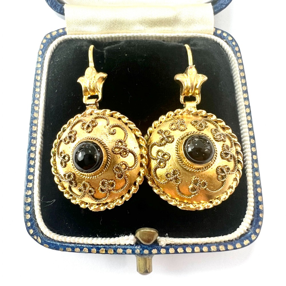 A pair of circular Victorian 15ct gold domed drop earrings featuring detailed scroll wirework, rope twist borders, and central dark agate cabochons.