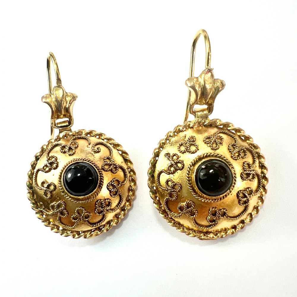 A pair of circular Victorian 15ct gold domed drop earrings featuring detailed scroll wirework, rope twist borders, and central dark agate cabochons. View V