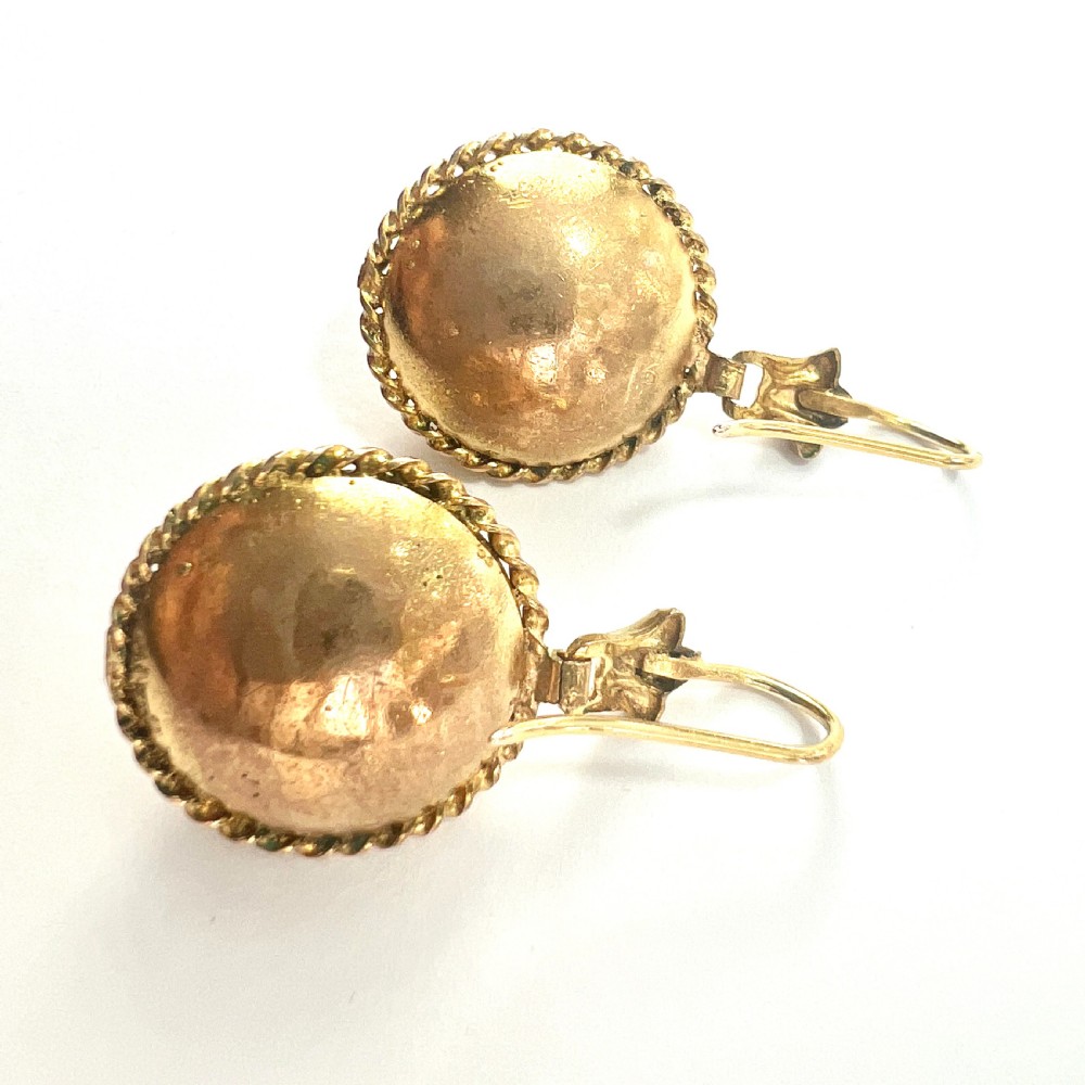 A pair of circular Victorian 15ct gold domed drop earrings featuring detailed scroll wirework, rope twist borders, and central dark agate cabochons. View VII