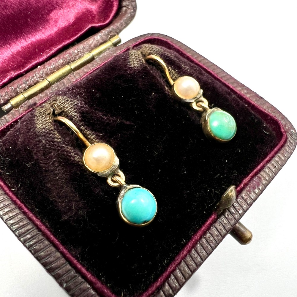 A pair of Victorian gold drop earrings with pearl accents and turquoise cabochons, resting inside a velvet presentation box. View II
