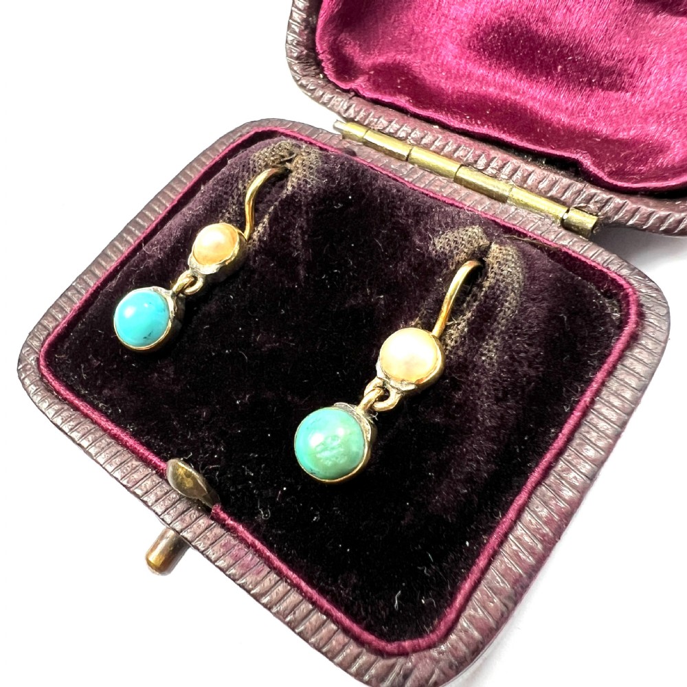 A pair of Victorian gold drop earrings with pearl accents and turquoise cabochons, resting inside a velvet presentation box. View III