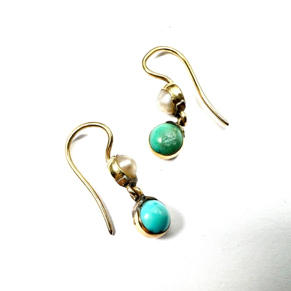 A pair of Victorian gold drop earrings with pearl accents and turquoise cabochons, resting inside a velvet presentation box. View IV