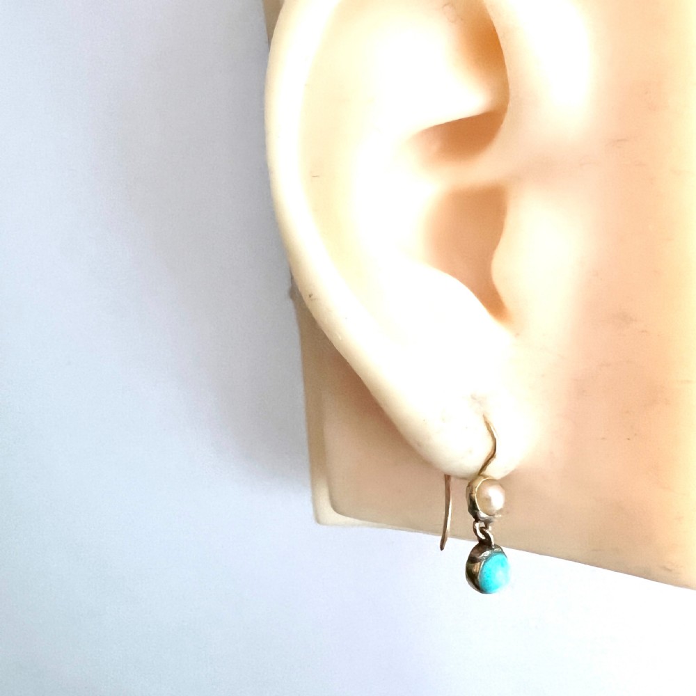 A pair of Victorian gold drop earrings with pearl accents and turquoise cabochons, resting inside a velvet presentation box. View VII
