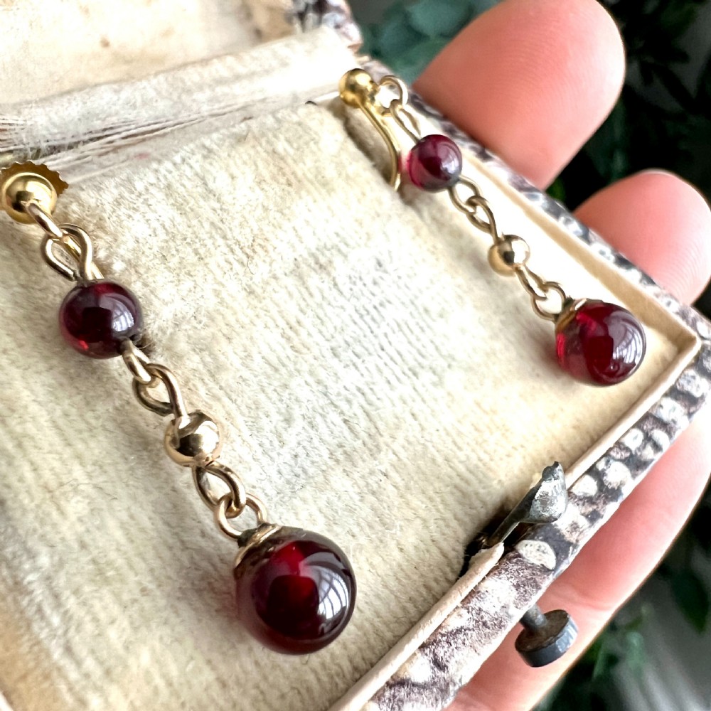 Pair of Edwardian 9ct yellow gold drop earrings with linked chains, spherical gold spacers, and polished dark red garnet beads on screw-back fittings. View III