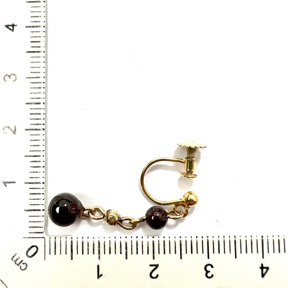 Pair of Edwardian 9ct yellow gold drop earrings with linked chains, spherical gold spacers, and polished dark red garnet beads on screw-back fittings. View VII