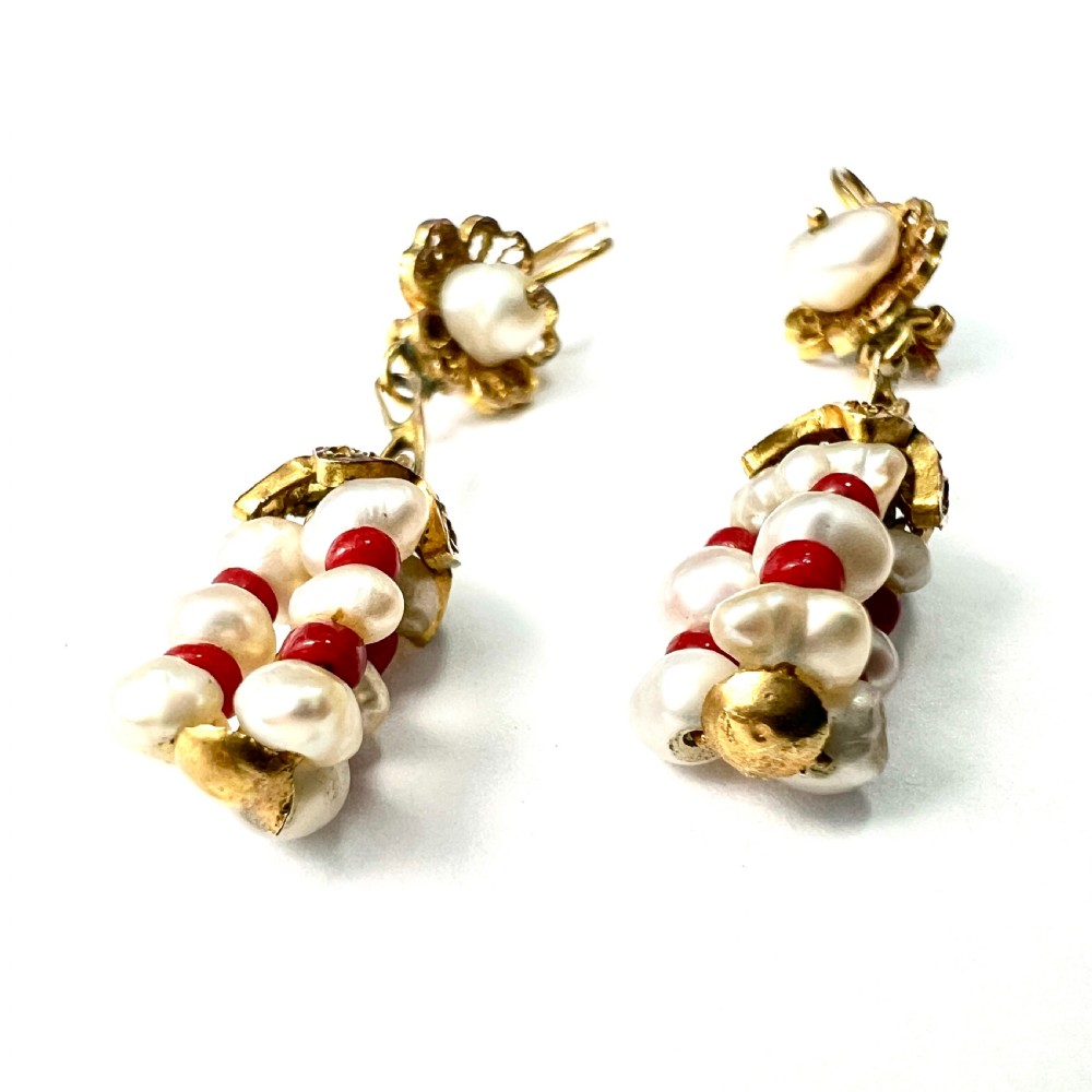 A pair of antique 14ct yellow gold drop earrings featuring top pearls set in filigree mounts above dangling clusters of natural pearls and small red coral beads. View II