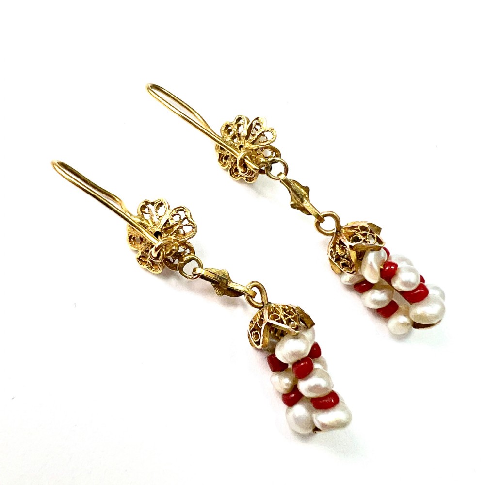 A pair of antique 14ct yellow gold drop earrings featuring top pearls set in filigree mounts above dangling clusters of natural pearls and small red coral beads. View III