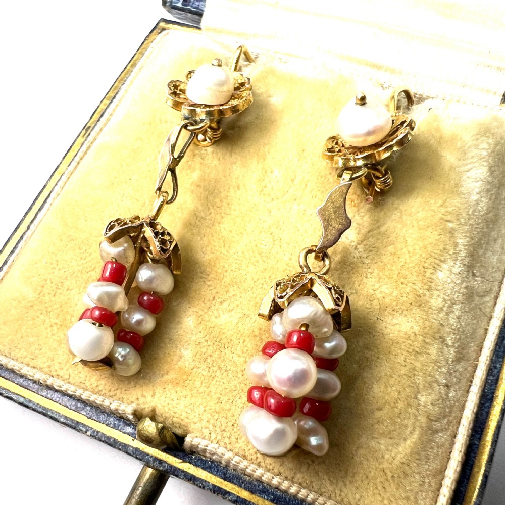 A pair of antique 14ct yellow gold drop earrings featuring top pearls set in filigree mounts above dangling clusters of natural pearls and small red coral beads. View VII