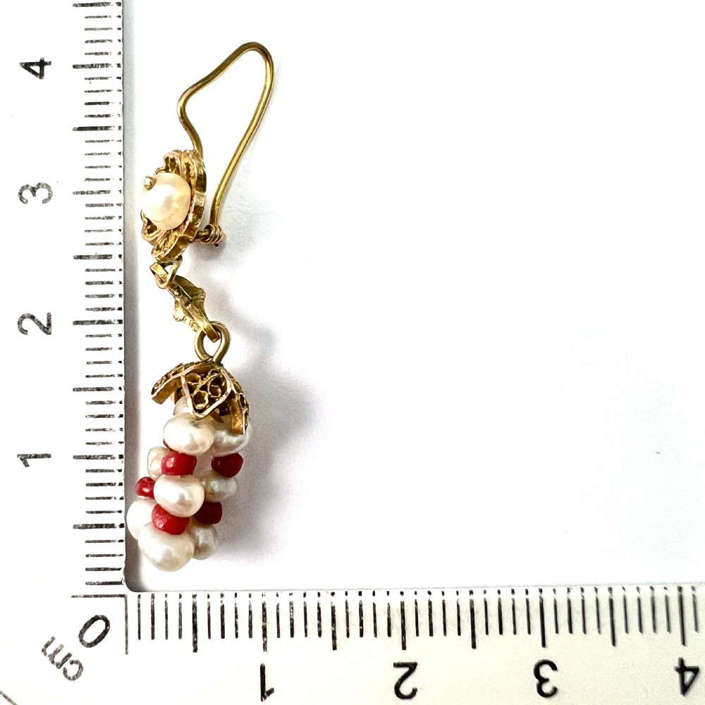 A pair of antique 14ct yellow gold drop earrings featuring top pearls set in filigree mounts above dangling clusters of natural pearls and small red coral beads. View VIII
