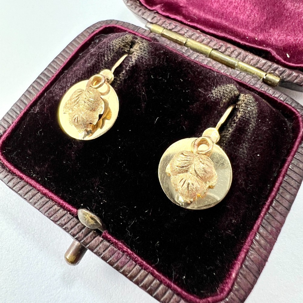 A pair of Victorian 18ct yellow gold circular disc dormeuse earrings featuring chased relief vine leaf motifs. View II