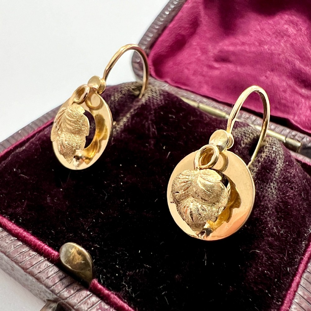 A pair of Victorian 18ct yellow gold circular disc dormeuse earrings featuring chased relief vine leaf motifs. View III