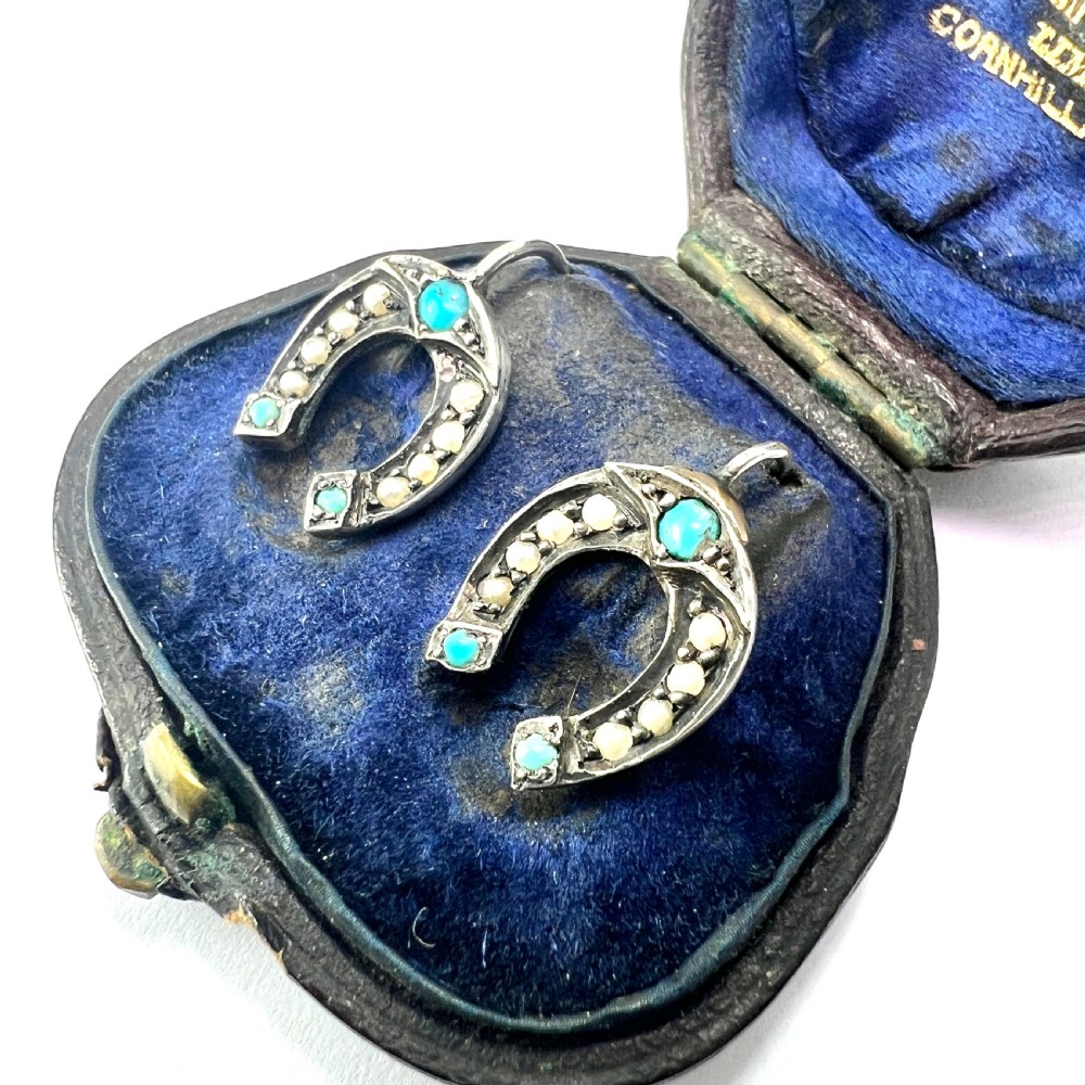 A pair of Victorian sterling silver horseshoe drop earrings set with turquoise cabochons and split seed pearls inside a velvet case. View II