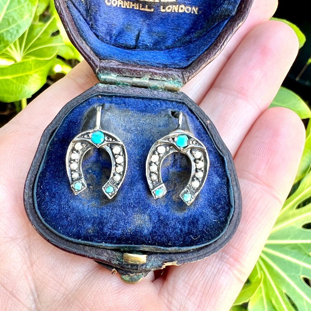 A pair of Victorian sterling silver horseshoe drop earrings set with turquoise cabochons and split seed pearls inside a velvet case. View VIII