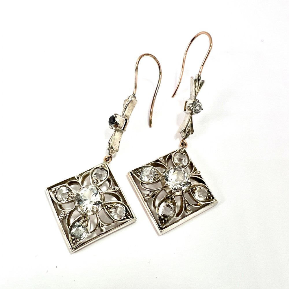 A pair of Victorian silver and 9ct gold drop earrings featuring diamond-shaped filigree openwork set with clear faceted rock crystals. View II