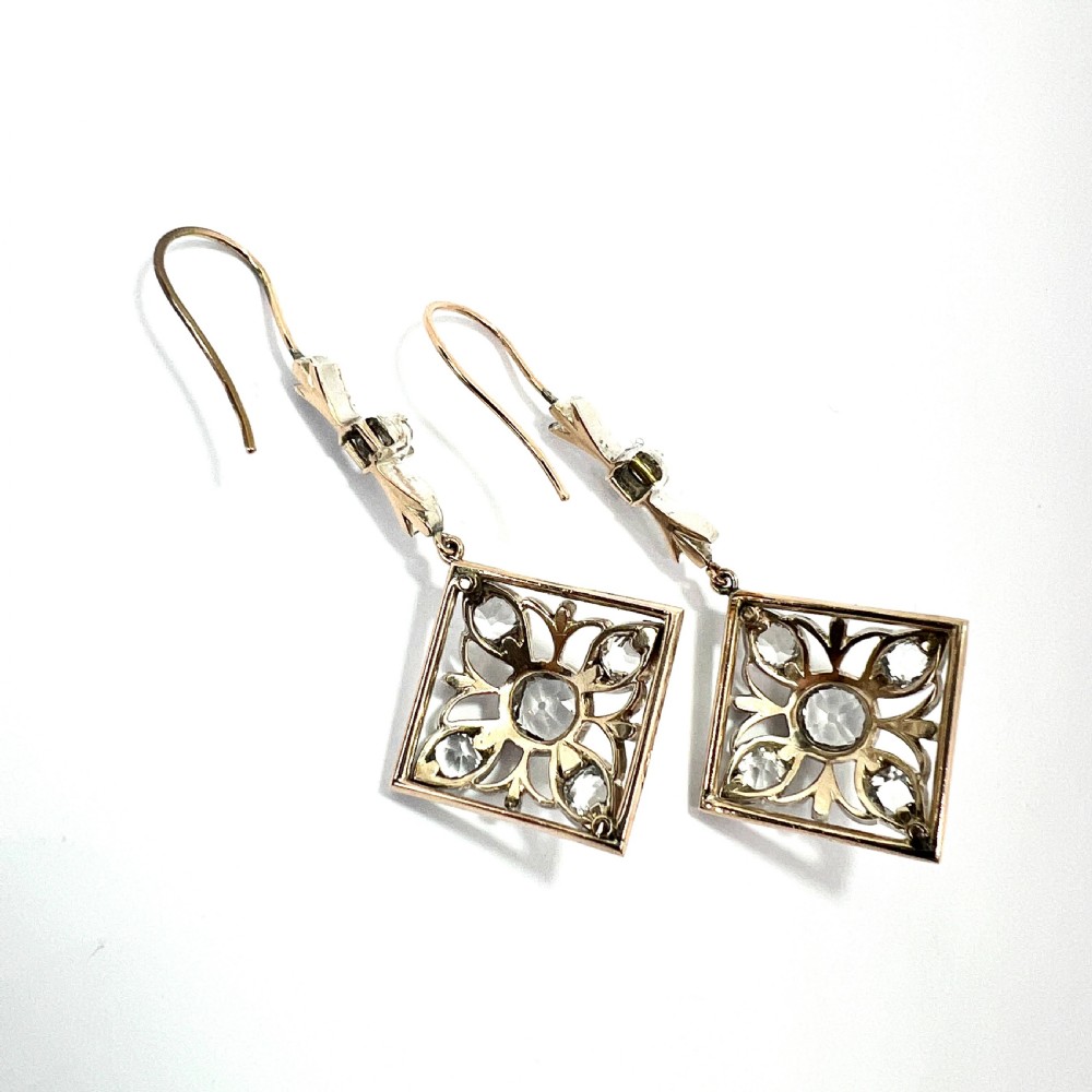 A pair of Victorian silver and 9ct gold drop earrings featuring diamond-shaped filigree openwork set with clear faceted rock crystals. View V