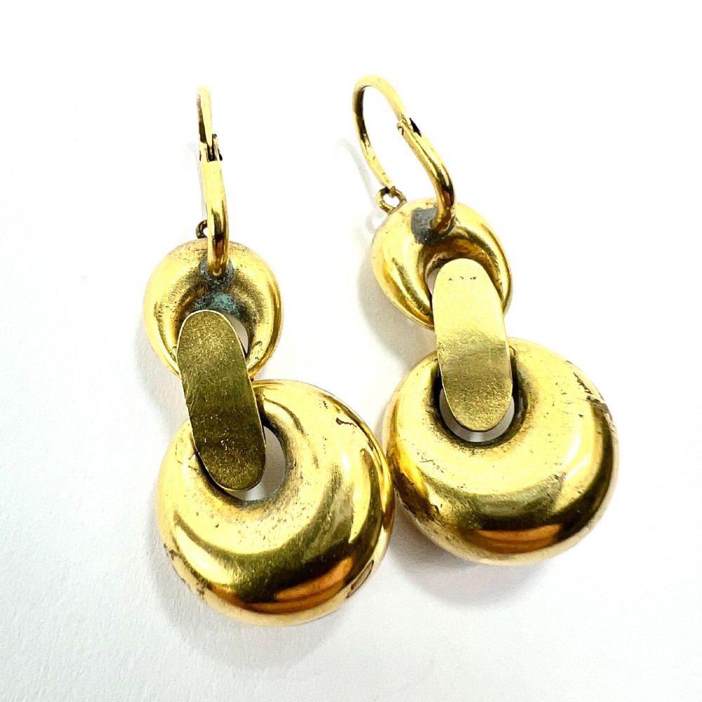 A pair of Victorian gold drop earrings featuring engraved hoop-shaped dangles inset with deep red garnet paste stones. View IX