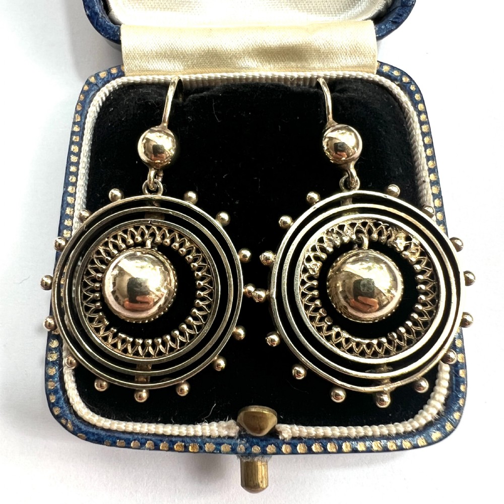 A pair of Victorian silver gilt drop earrings featuring concentric circular tiers around a polished central dome with beaded decorative accents.