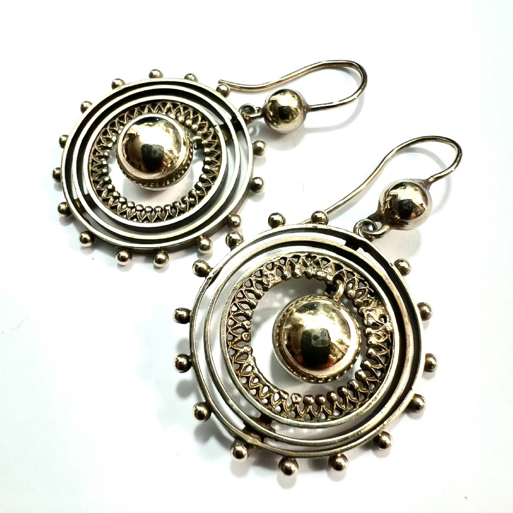 A pair of Victorian silver gilt drop earrings featuring concentric circular tiers around a polished central dome with beaded decorative accents. View III