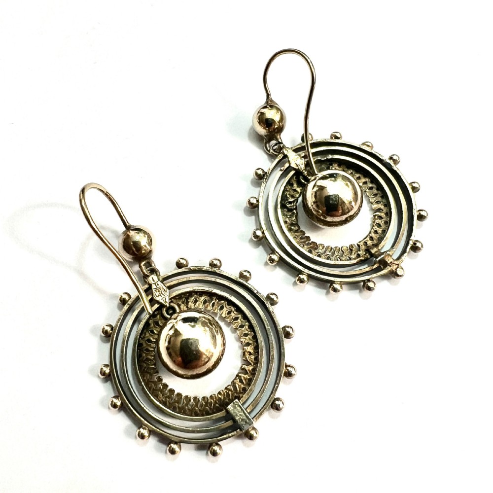 A pair of Victorian silver gilt drop earrings featuring concentric circular tiers around a polished central dome with beaded decorative accents. View VI