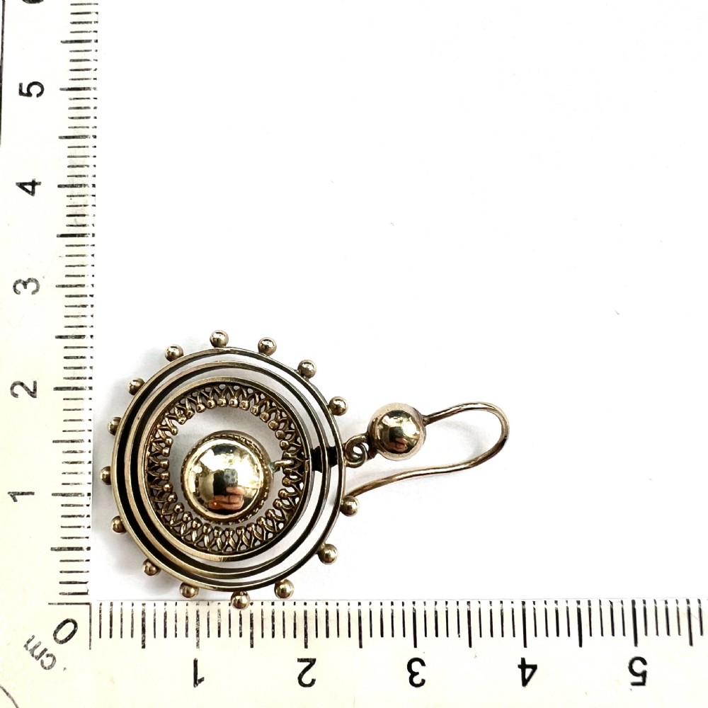 A pair of Victorian silver gilt drop earrings featuring concentric circular tiers around a polished central dome with beaded decorative accents. View VII