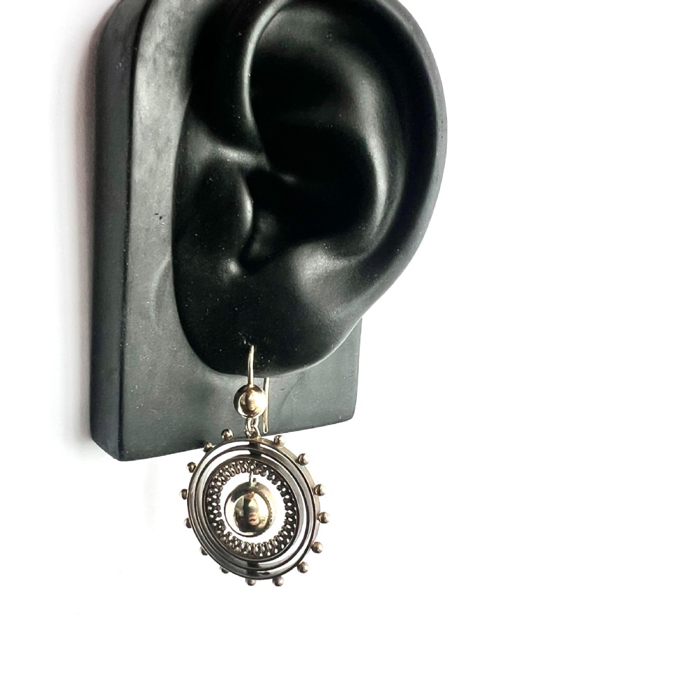 A pair of Victorian silver gilt drop earrings featuring concentric circular tiers around a polished central dome with beaded decorative accents. View VIII