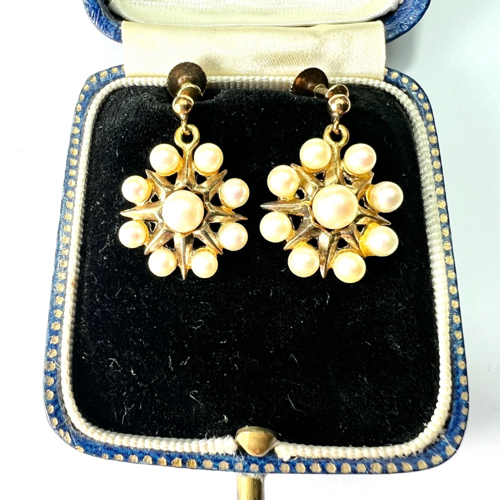 A pair of vintage 9ct gold screwback earrings featuring a central pearl surrounded by a sunburst frame set with smaller pearls. View III