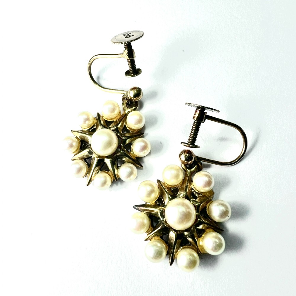 A pair of vintage 9ct gold screwback earrings featuring a central pearl surrounded by a sunburst frame set with smaller pearls. View VI