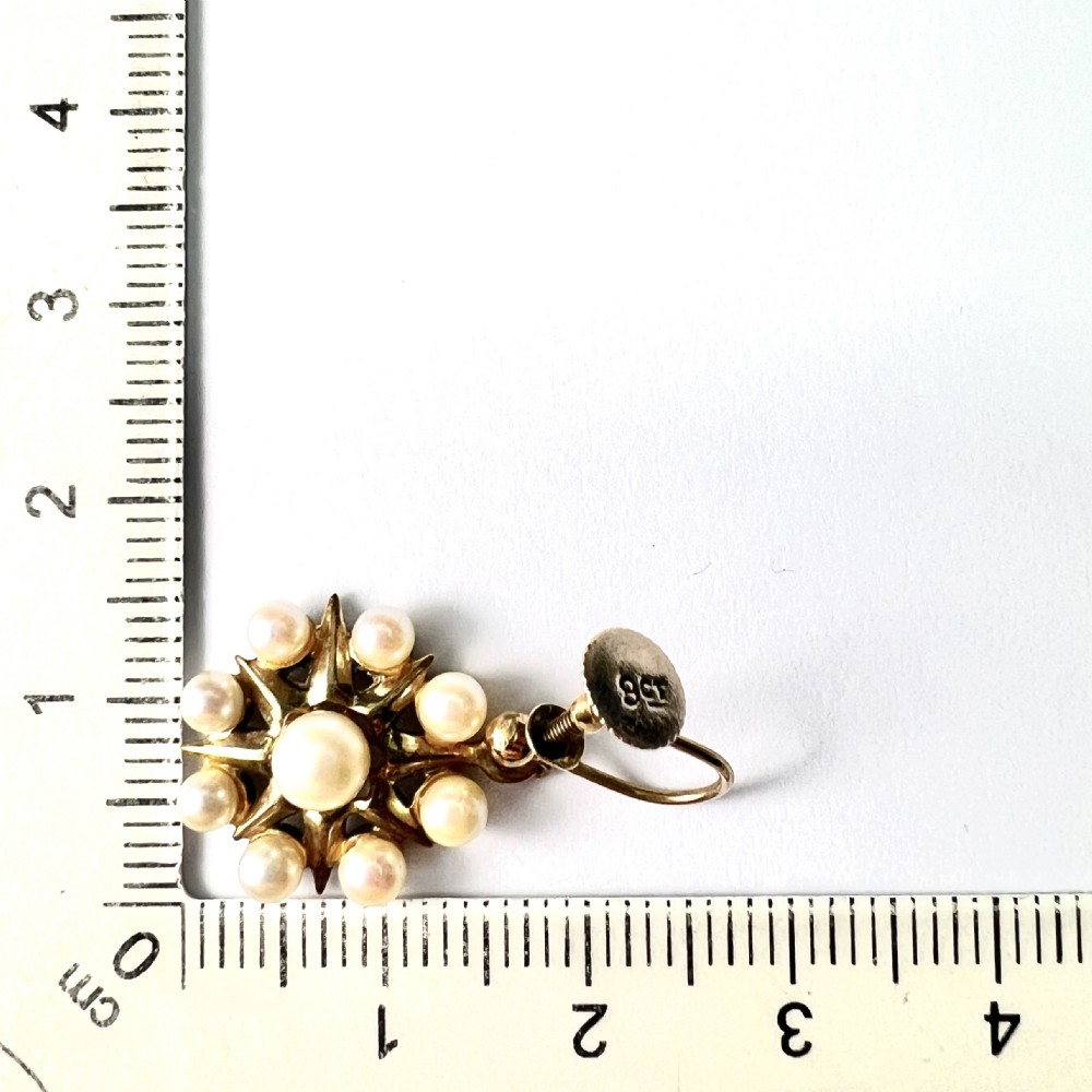 A pair of vintage 9ct gold screwback earrings featuring a central pearl surrounded by a sunburst frame set with smaller pearls. View VII