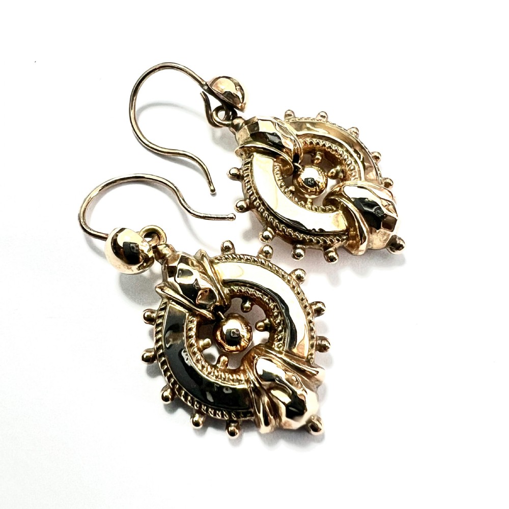 A pair of Victorian 9ct yellow gold drop earrings featuring circular wheel-like motifs with central spherical beads suspended from wire hooks. View VI