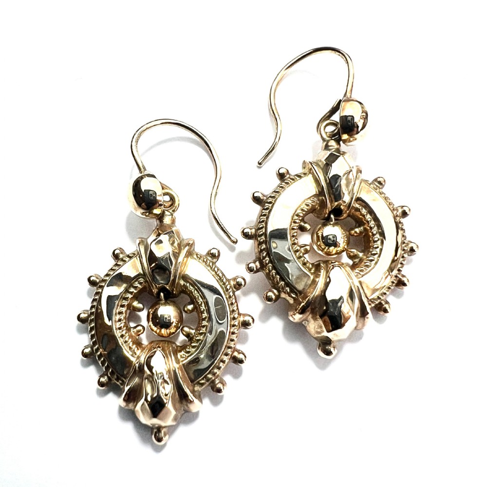 A pair of Victorian 9ct yellow gold drop earrings featuring circular wheel-like motifs with central spherical beads suspended from wire hooks. View VIII