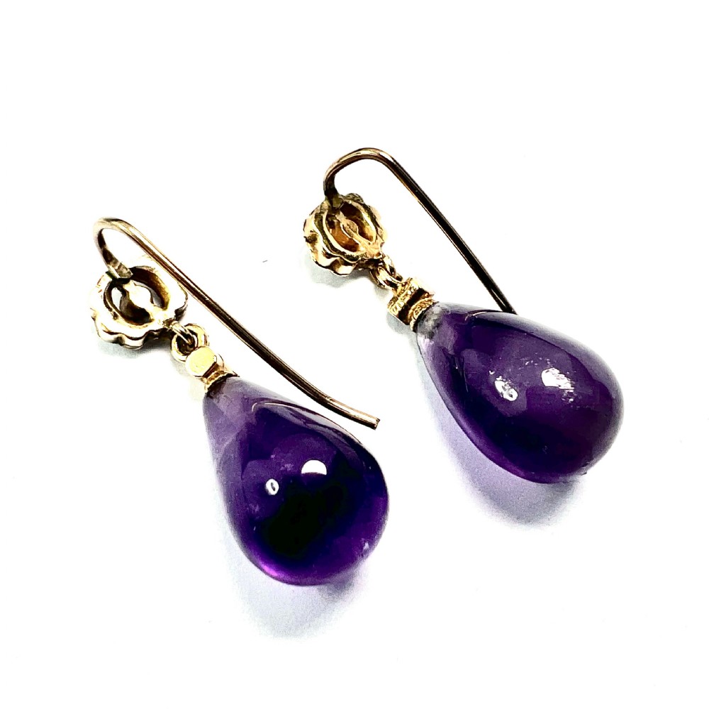 A pair of Victorian gold drop earrings featuring teardrop cabochon amethysts suspended from pearl-set floral clusters inside a fitted velvet box. View III