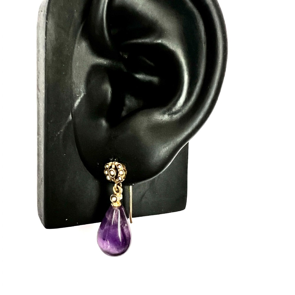 A pair of Victorian gold drop earrings featuring teardrop cabochon amethysts suspended from pearl-set floral clusters inside a fitted velvet box. View VIII