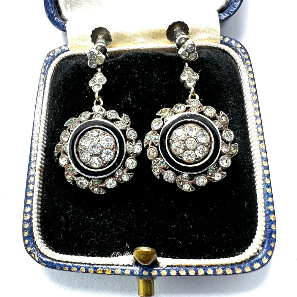 A pair of antique silver drop earrings featuring black enamel concentric rings, pave paste glass centres, and screwback fittings.