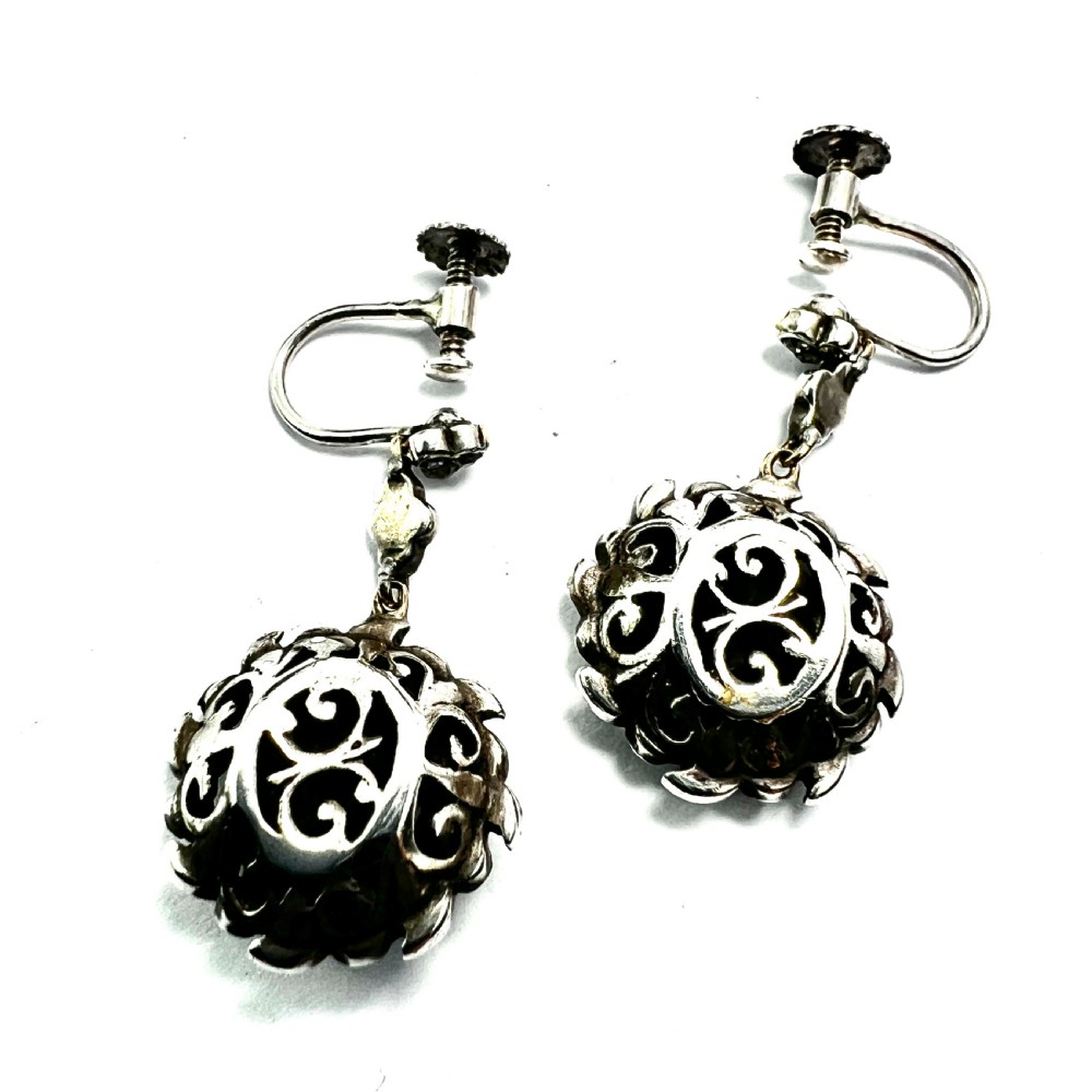 A pair of antique silver drop earrings featuring black enamel concentric rings, pave paste glass centres, and screwback fittings. View V