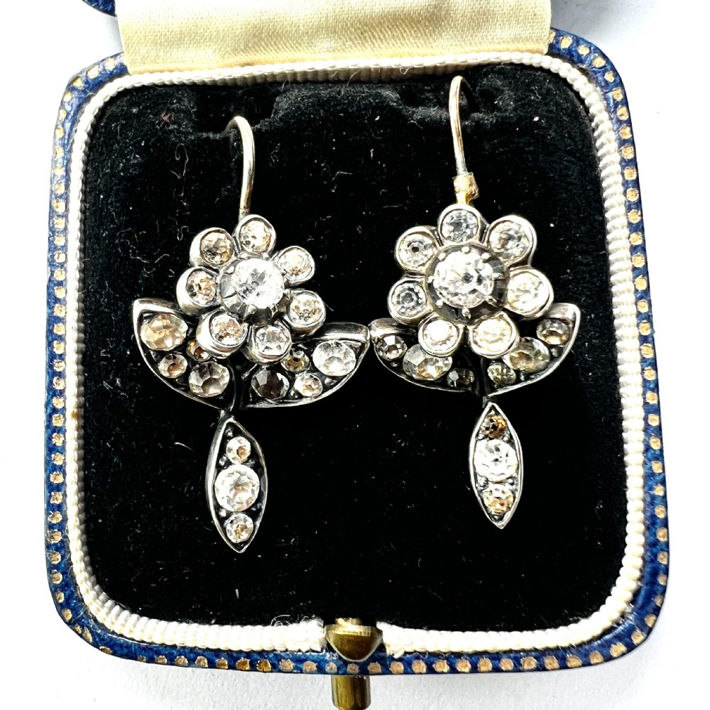 A pair of Georgian floral drop earrings featuring closed-back foil-set clear paste stones with black dots set in silver with gold fittings.