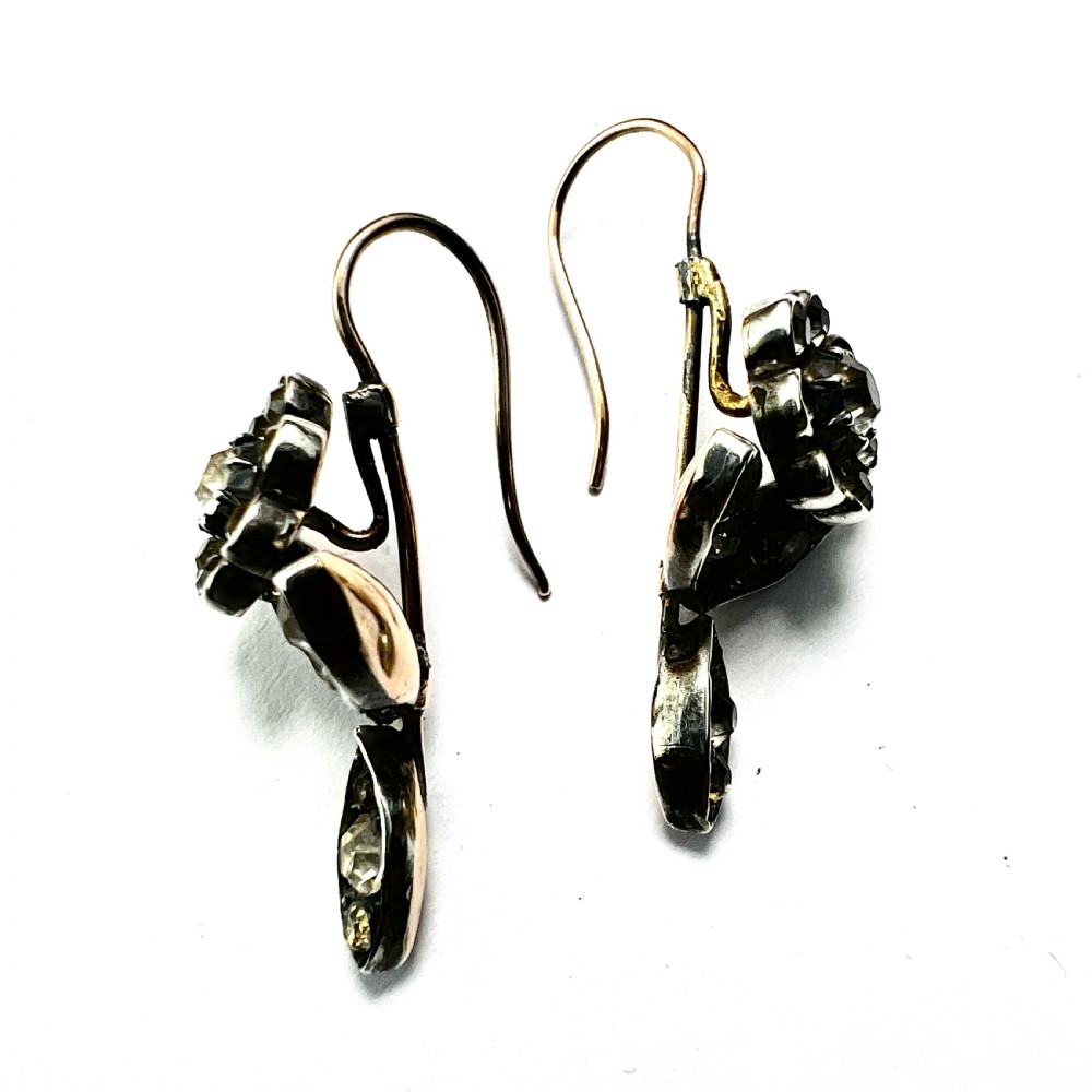 A pair of Georgian floral drop earrings featuring closed-back foil-set clear paste stones with black dots set in silver with gold fittings. View III