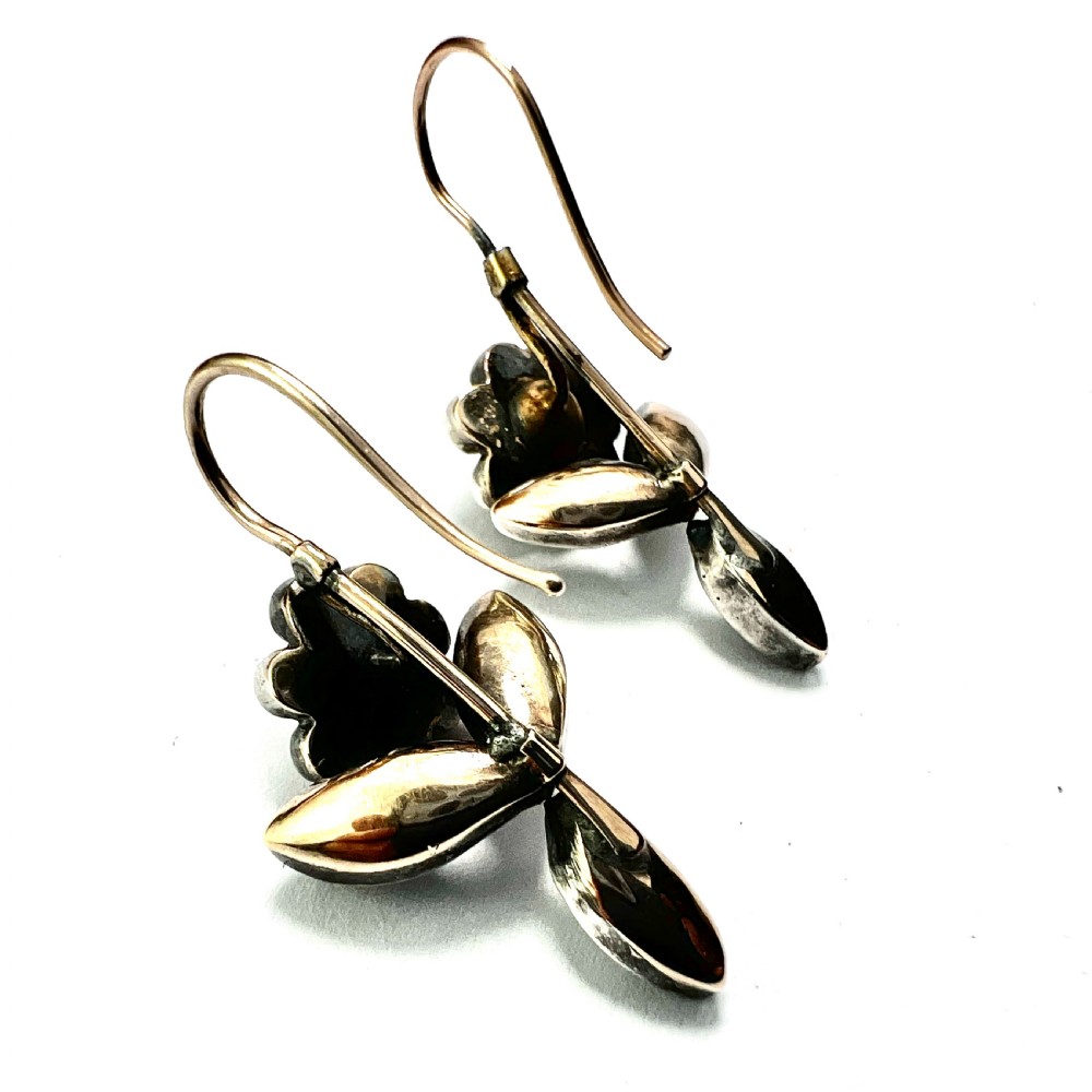 A pair of Georgian floral drop earrings featuring closed-back foil-set clear paste stones with black dots set in silver with gold fittings. View V