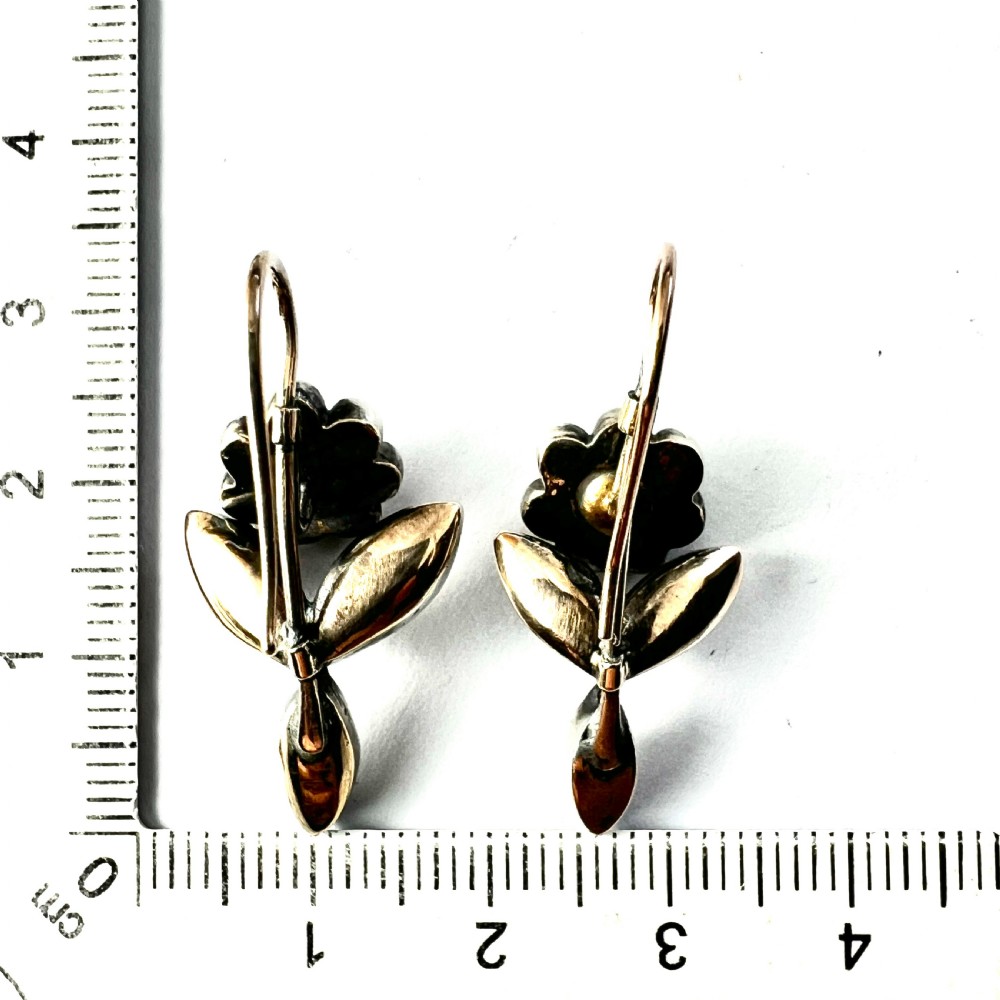 A pair of Georgian floral drop earrings featuring closed-back foil-set clear paste stones with black dots set in silver with gold fittings. View VI