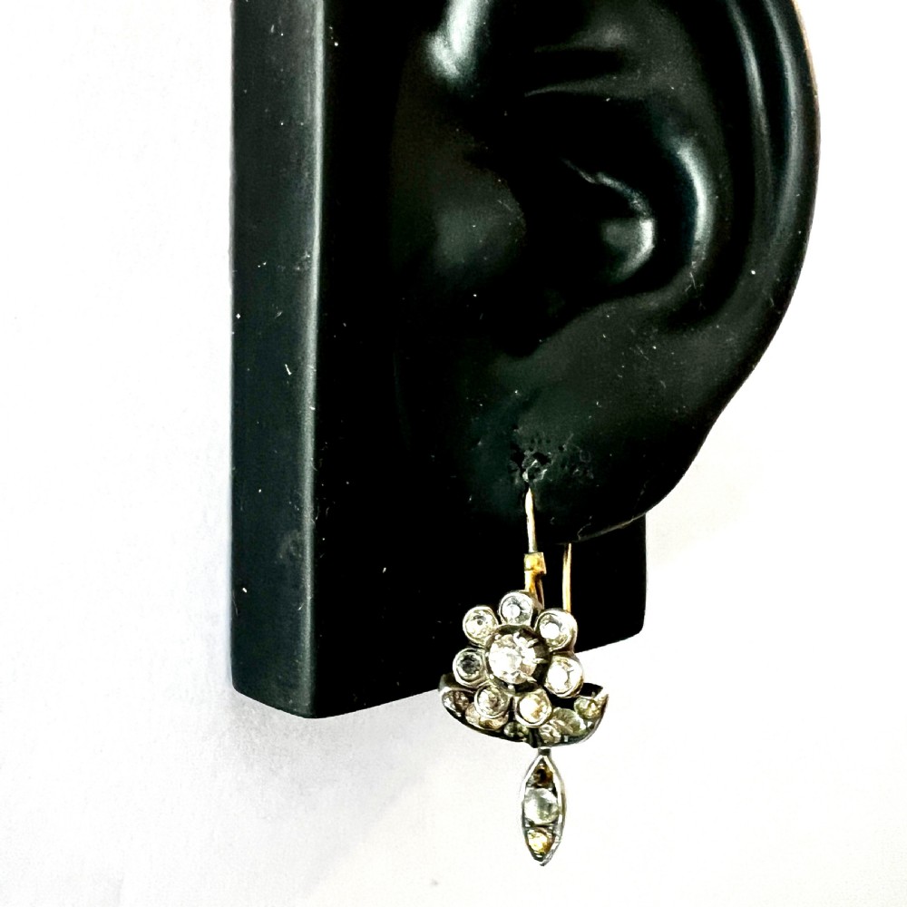 A pair of Georgian floral drop earrings featuring closed-back foil-set clear paste stones with black dots set in silver with gold fittings. View VII