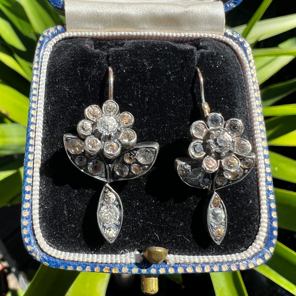 A pair of Georgian floral drop earrings featuring closed-back foil-set clear paste stones with black dots set in silver with gold fittings. View IX