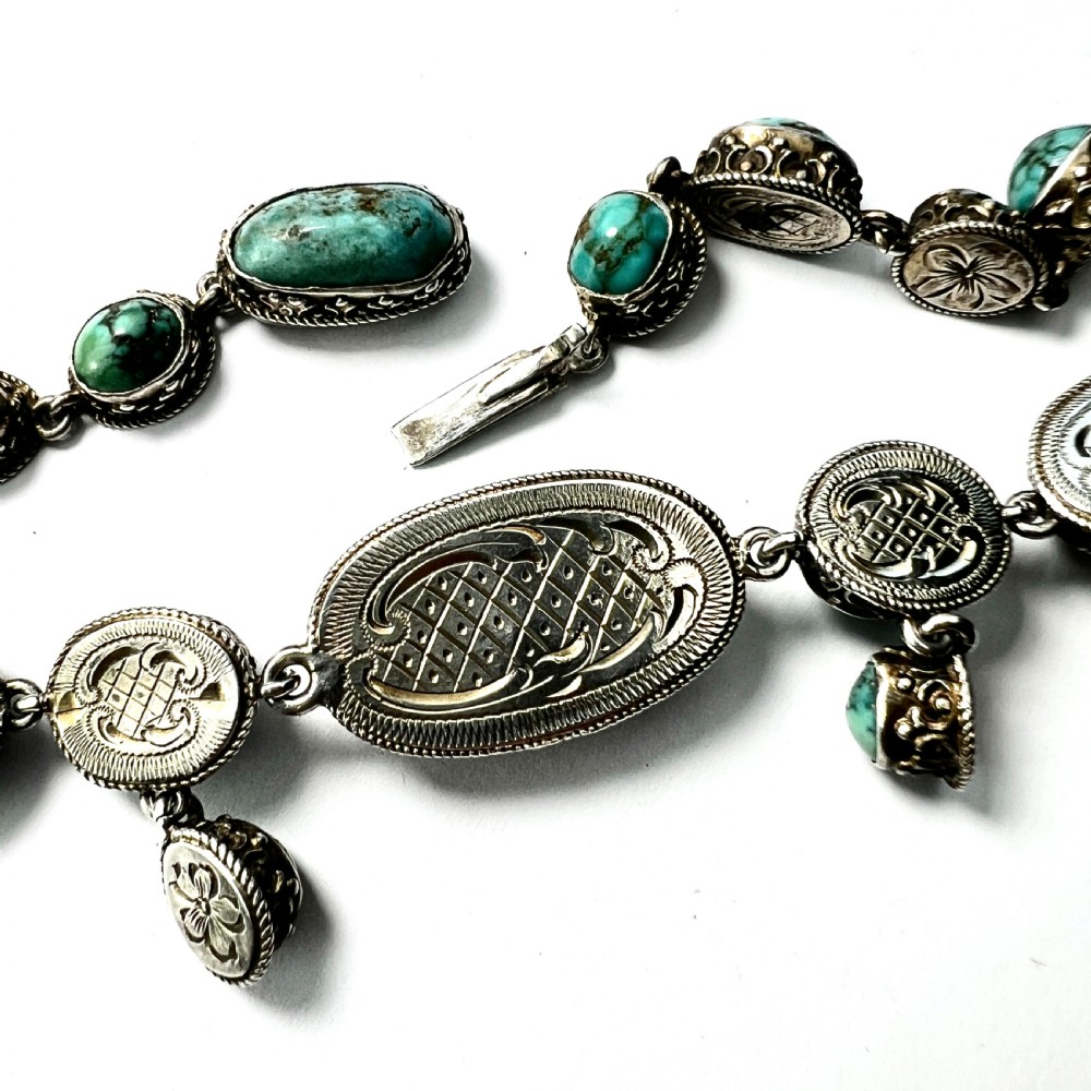 An antique silver jewellery parure consisting of a cabochon turquoise matrix link necklace, drop earrings, and a statement ring. View VIII