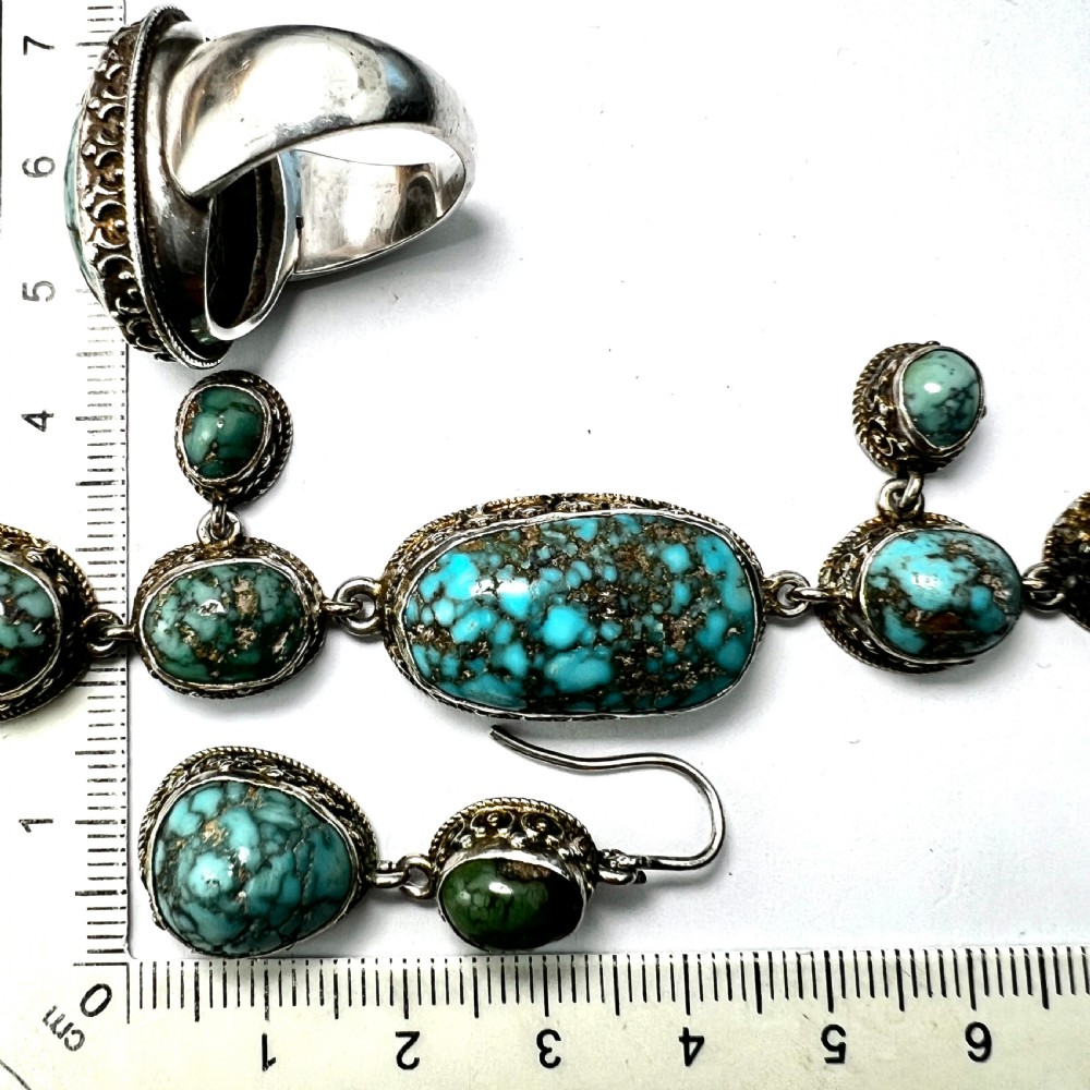 An antique silver jewellery parure consisting of a cabochon turquoise matrix link necklace, drop earrings, and a statement ring. View IX