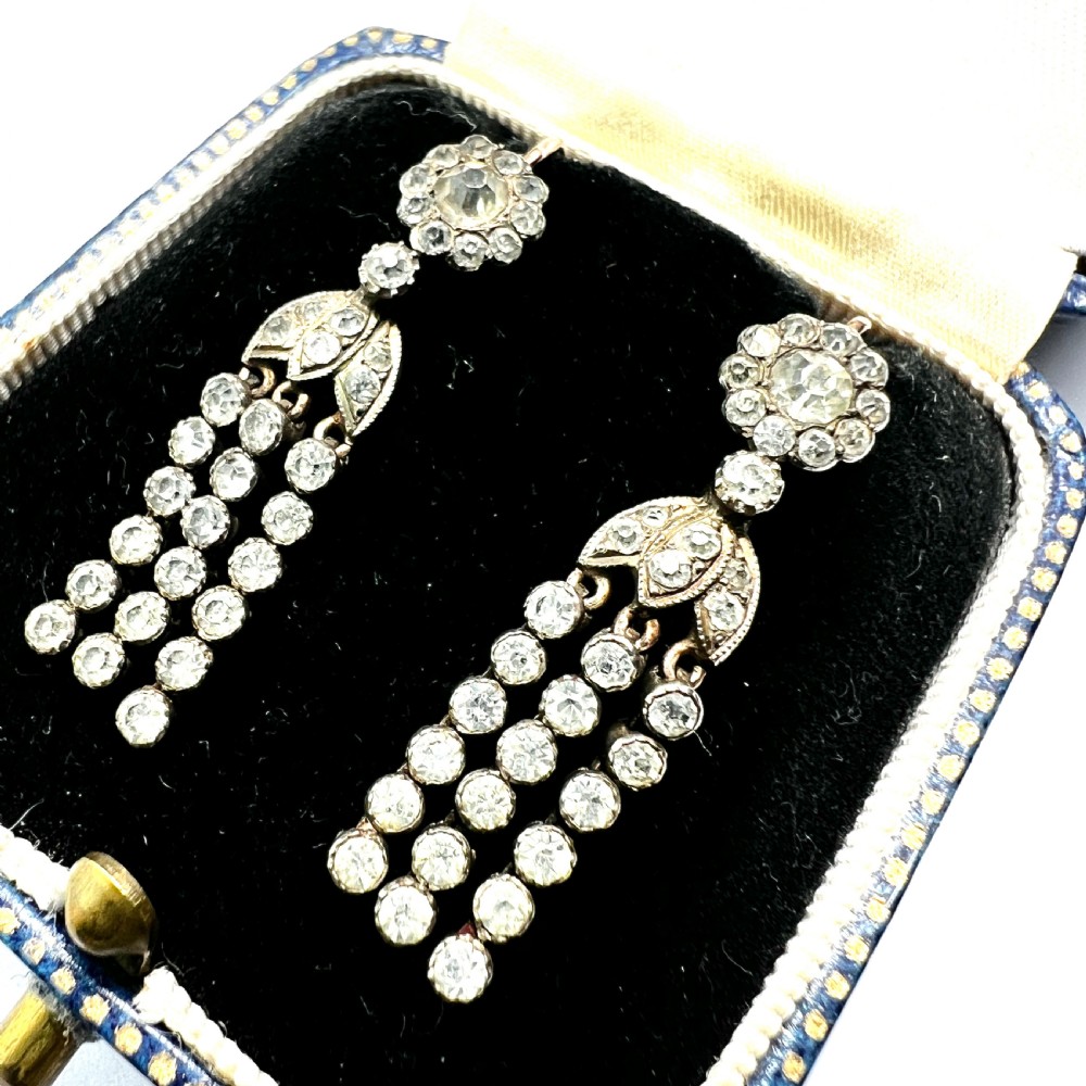 A pair of Victorian silver and gold drop earrings featuring floral cluster tops and articulated paste tassel strands set with clear stones. View II