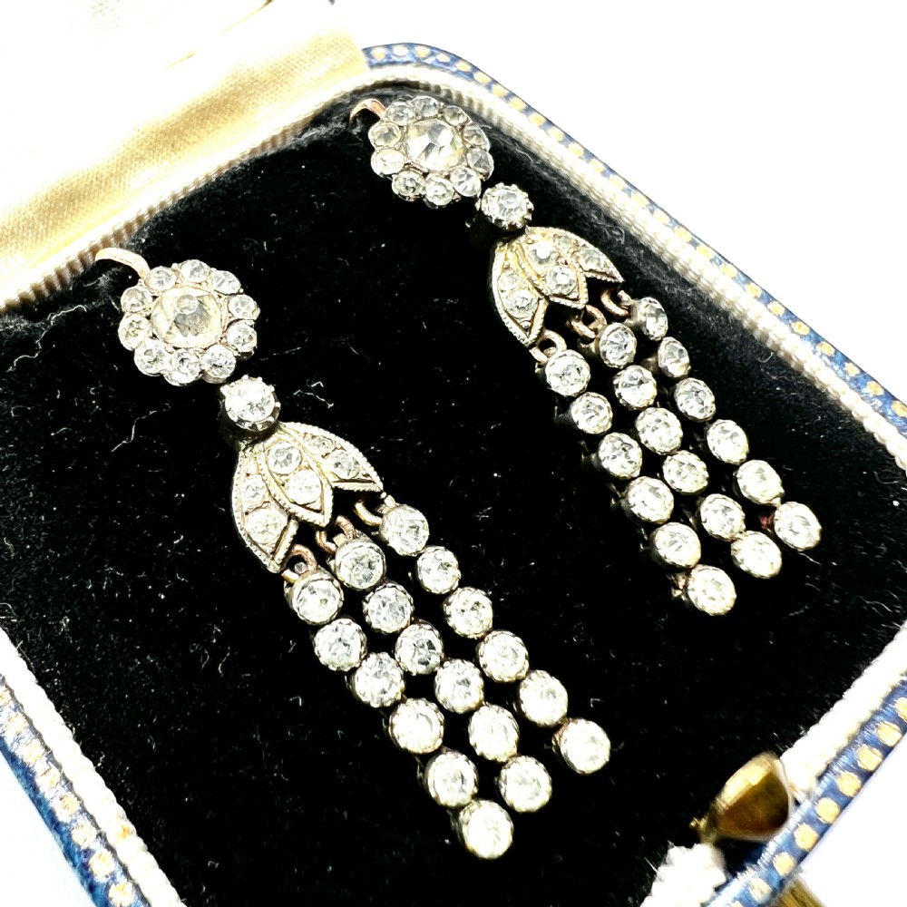 A pair of Victorian silver and gold drop earrings featuring floral cluster tops and articulated paste tassel strands set with clear stones. View III