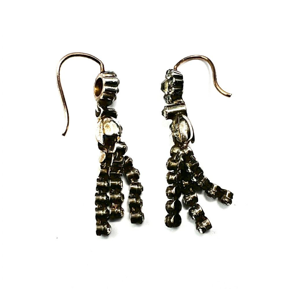 A pair of Victorian silver and gold drop earrings featuring floral cluster tops and articulated paste tassel strands set with clear stones. View VI