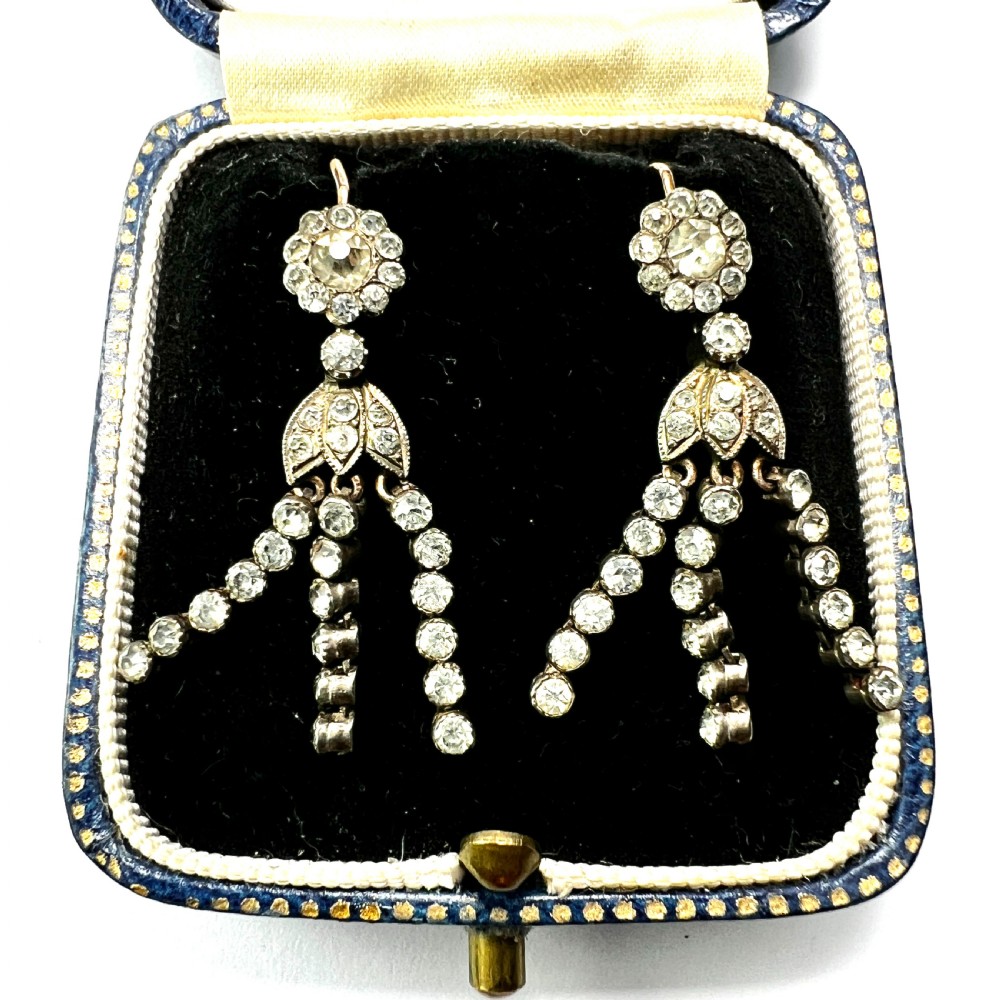 A pair of Victorian silver and gold drop earrings featuring floral cluster tops and articulated paste tassel strands set with clear stones. View VII