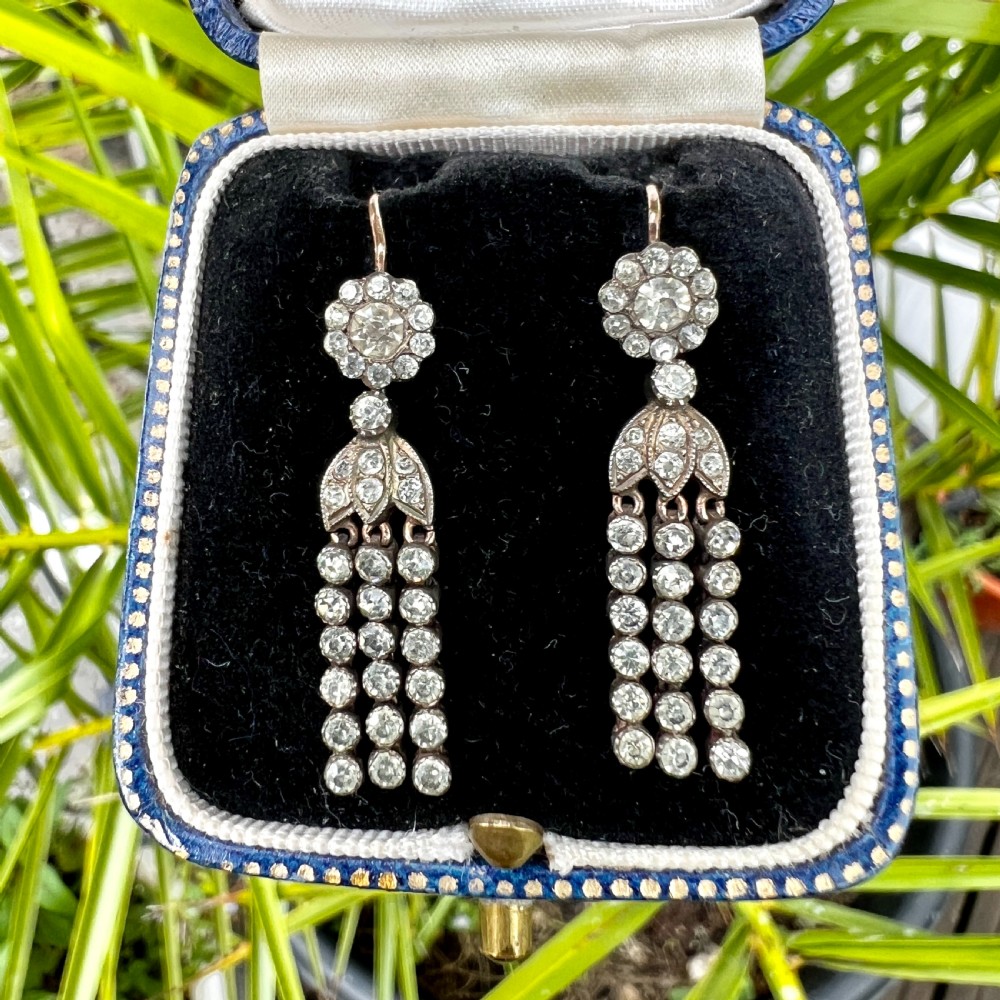 A pair of Victorian silver and gold drop earrings featuring floral cluster tops and articulated paste tassel strands set with clear stones. View IX